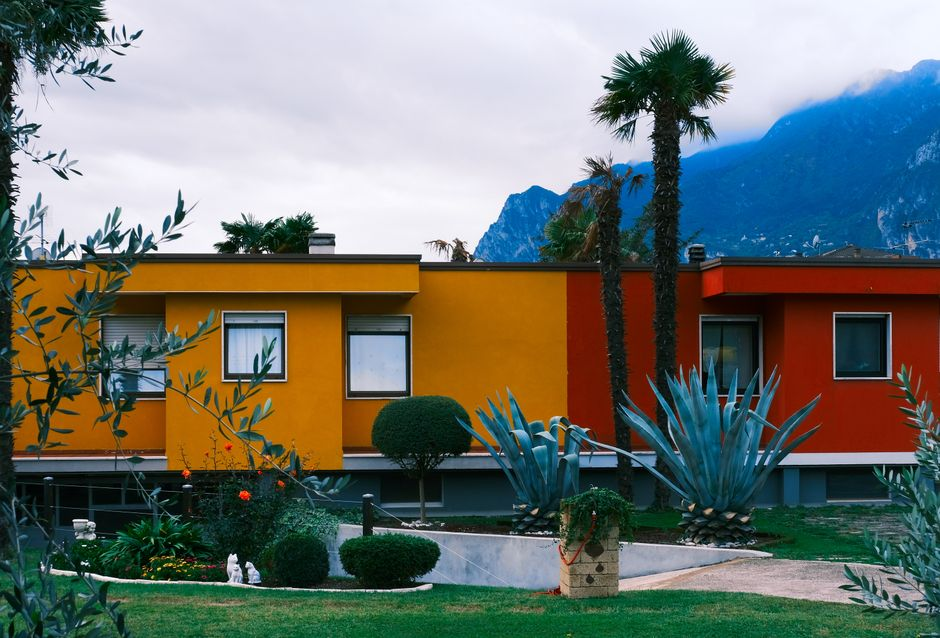 Bright modern houses amidst lush tropical garden and mountain view.