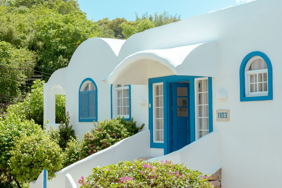 Charming white house with blue accents nestled in lush greenery in the Philippines.