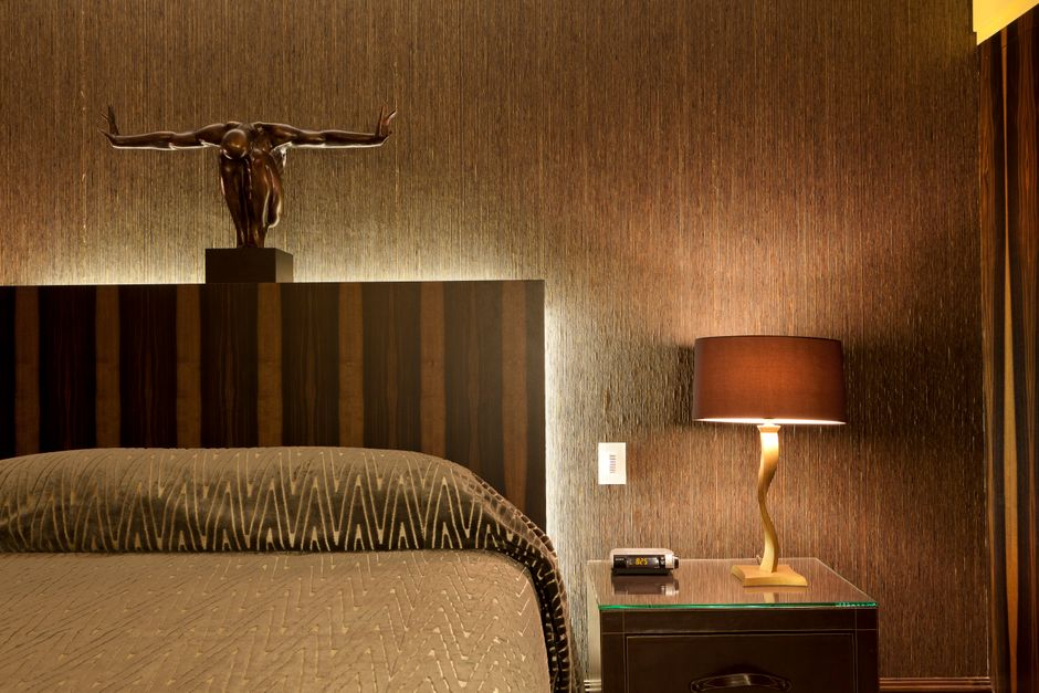 A luxurious bedroom featuring a bronze sculpture, modern lamp, and stylish decor.