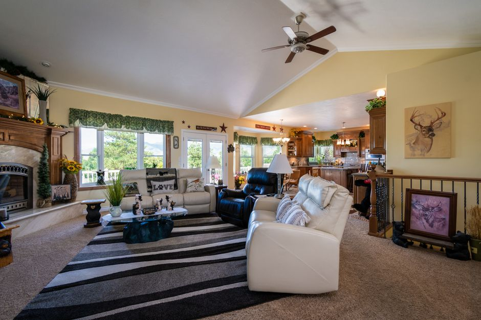 Spacious living room featuring a fireplace, modern decor, and comfortable furniture, with a view to the outdoors.